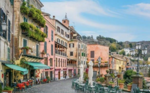 Picturesque Italian street scene with tables and chairs, perfect for enjoying a meal al fresco.